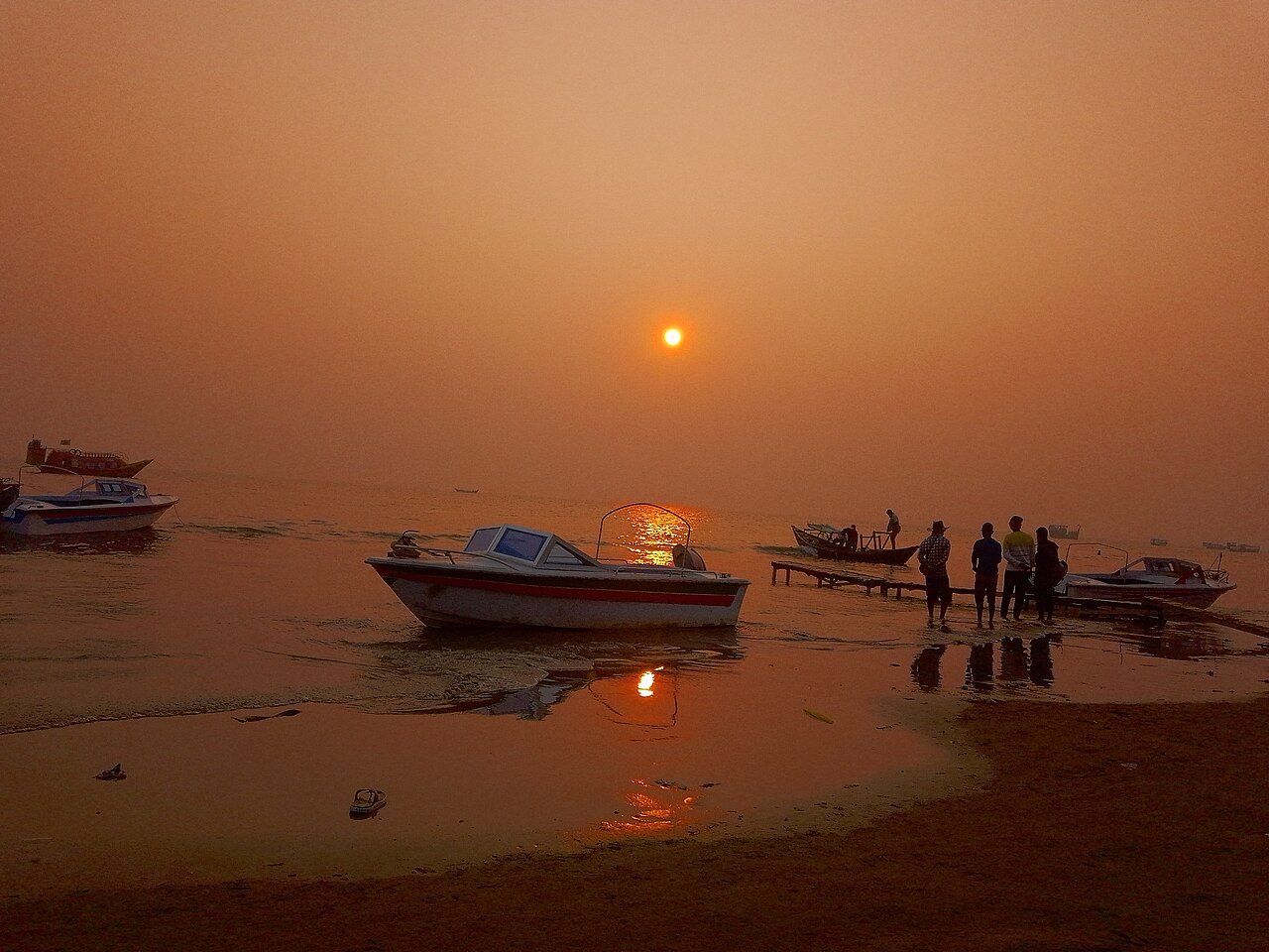 কুয়াকাটা সৈকতে সূর্যাস্ত ও নোঙর-করা নৌকা